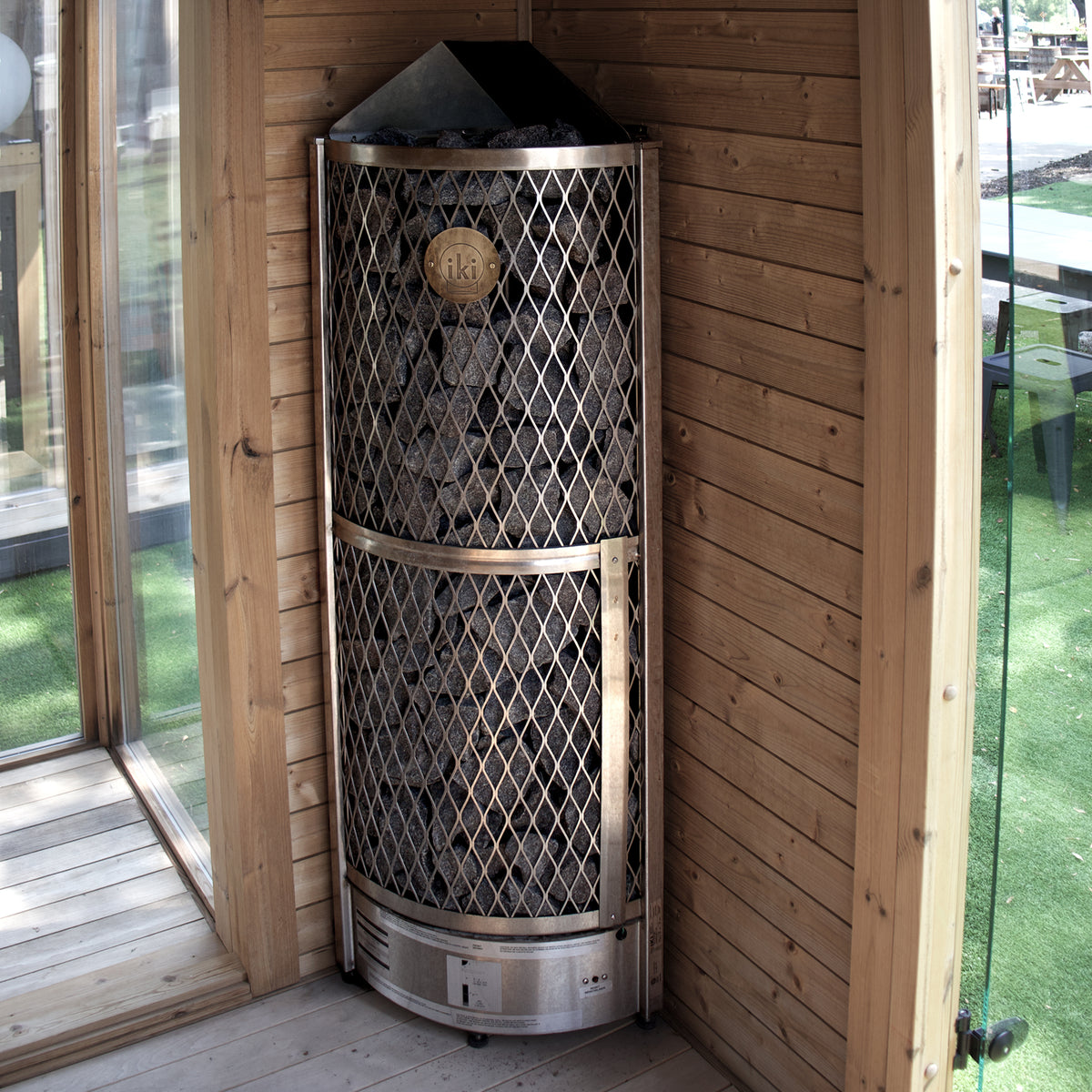IKI Corner 6 kW Wi-Fi sauna heater in an outdoor sauna, front view