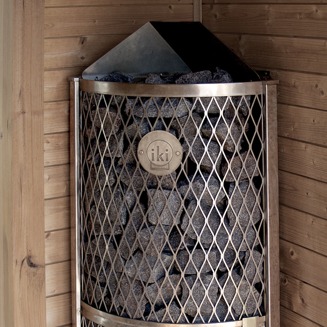 IKI Corner 6 kW sauna heater in the corner of a cedar sauna room